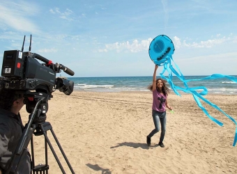 Programledaren Tika Lahne flyger drake på stranden i ett avsnitt som handlar om det spanska påskfirandet. Foto: Utbildningsradion